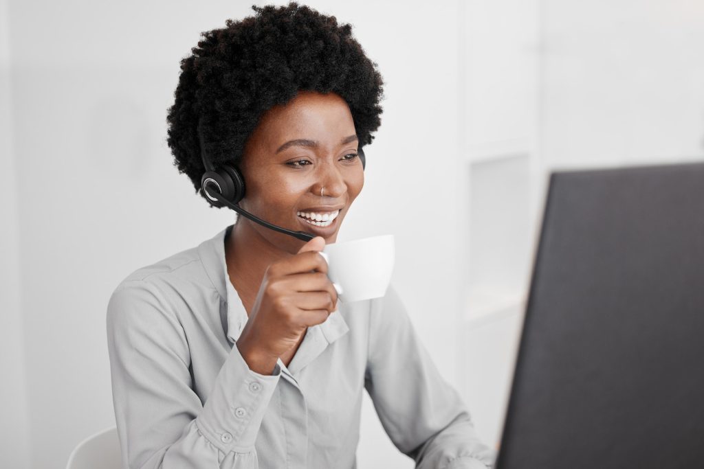 Call center, customer support and coffee with a woman consultant working on a computer in her offic