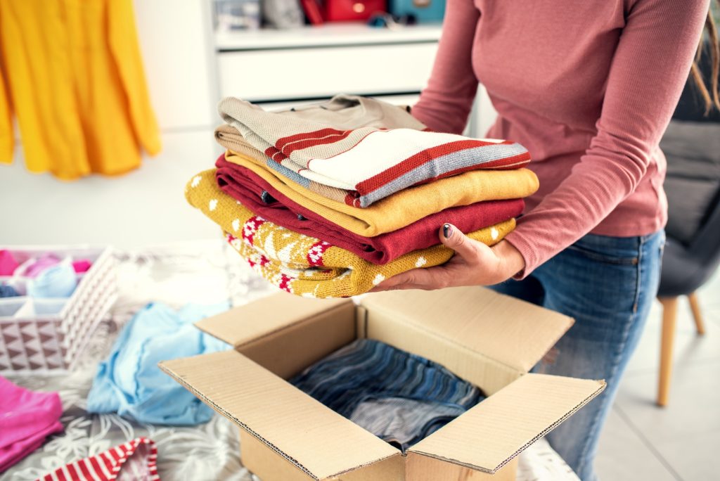 Woman putting her clothes in a delivery box